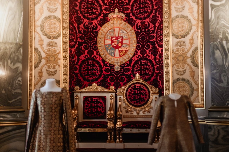 The Danish royal throne in the Throne Room of Christiansborg Palace, with a red velvet background and gold trim.