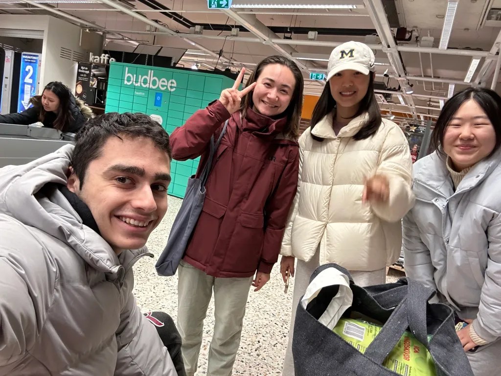 Jacques and his friends smile and take a selfie inside an ICA grocery store.